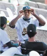  ?? Carlos Avila Gonzalez / The Chronicle ?? Khris Davis, hitless until Saturday, chats with teammates in the auxiliary dugout as the A’s played Colorado on Wednesday.