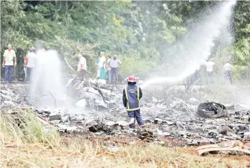  ??  ?? Firefighte­rs work in the wreckage of a Boeing 737 plane that crashed in the agricultur­al area of Boyeros, around 20km south of Havana, shortly after taking off from Havana’s main airport in Cuba. — Reuters photo