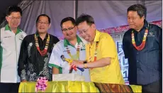  ??  ?? Dr Sim (second right) uses a hammer and pick to get a CD frozen in a block of ice to launch ‘Pesta Rakyat’.