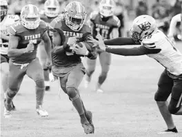  ?? STEPHEN M. DOWELL/ORLANDO SENTINEL ?? Orange City University running back Demari Taylor evades defenders as he runs the opening kickoff back for a touchdown against Winter Springs on Friday night. The Titans won 41-7 for the first true home win in school history.