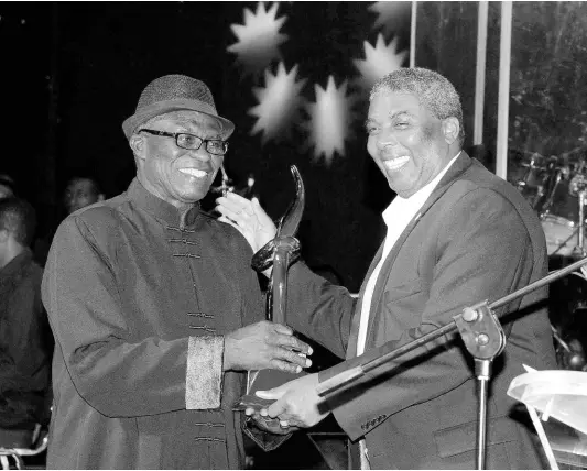  ?? ?? FILE
Leon Mitchell (right) of Jamaica National Building Society presents Winston ‘Sparrow’ Martin with his JaRIA Honour Award at the ceremony held at the Courtleigh Auditorium in February 2014.