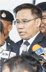  ?? (AFP) ?? A supporter (left) holds up a fan with the image of Thailand’s former Prime Minister Yingluck Shinawatra outside the court, while her main lawyer Norawit Larlaeng (centre) addresses the media after the verdict, in Bangkok on Wednesday; a file photo of...