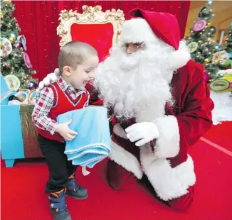  ?? JEAN LEVAC/OTTAWA CITIZEN ?? Three-year-old Jacques Guimont-Tardif visits Santa at Les Promenades Gatineau as the mall hosted a private, quiet meeting with St. Nick for children with autism before the mall opened on Saturday.