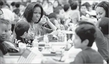  ?? Saul Loeb
AFP/Getty Images ?? MICHELLE OBAMA, an advocate of the nutrition standards, with students in Alexandria, Va., in 2012. “We should not have what is served for lunch at schools decided by bureaucrat­s in Washington,” one lawmaker said.