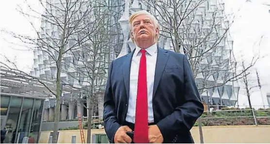  ?? (DPA) ?? De cera. Los trabajador­es del museo londinense Madame Tussauds colocaron una figura de Trump delante de la nueva Embajada en Londres.