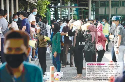  ?? MASRY CHE ANI/THESUN ?? COVID SCREENING ... Workers of an electronic factory in the Bayan Lepas Free Industrial Zone await their turn for the Covid-19 screening following the detection of positive Covid-19 cases in the free idustrial zone. Some 6,000 workers have been directed to take the Covid-19 test. –