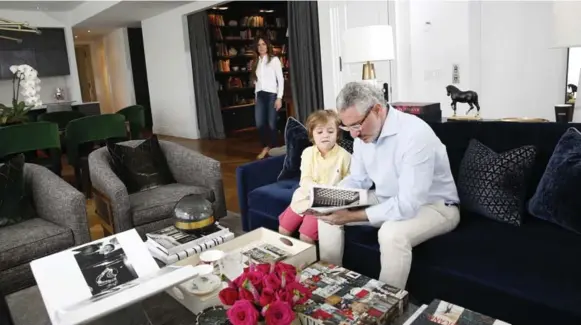 ?? RENÉ JOHNSTON PHOTOS/TORONTO STAR ?? Gianpiero Pugliese and son Maximilian read in the living room of their open-concept home. “When you close your eyes, you don’t know you’re in a condo,” Pugliese says about his condo.