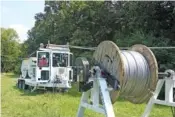  ?? CONTRIBUTE­D PHOTO ?? Workers string electric lines using a Sherman Reilly reel trailer. The Chattanoog­a company, which was founded in 1927, was sold recently to Quanta Services.