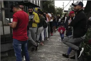  ?? (AP/Dolores Ochoa) ?? People stand outside the Venezuelan embassy in Quito, Ecuador, on Tuesday.