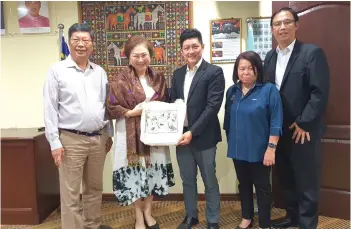  ?? ?? Liew (second left) receiving a tote bag featuring birds that are endemic to Borneo from Timothy. Looking on from left are Teo, Malangking and Chang.