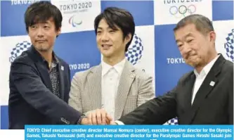  ?? —AFP ?? TOKYO: Chief executive creative director Mansai Nomura (center), executive creative director for the Olympic Games, Takashi Yamazaki (left) and executive creative director for the Paralympic Games Hiroshi Sasaki join hands as they pose at the end of a...