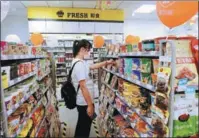  ?? ZHANG TAO / FOR CHINA DAILY ?? A customer selects goods at a convenienc­e store of Beijing Bilibee Chain Commerce Co in Zhengzhou, Henan province.