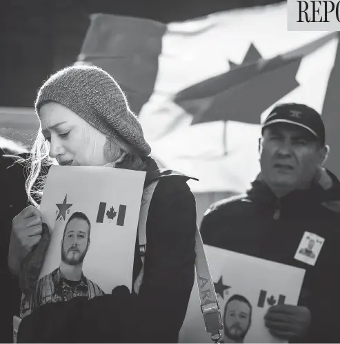  ?? TYLER ANDERSON / NATIONAL POST ?? People hold pictures of John Gallagher during a memorial ceremony in Toronto on Friday. The body of the Canadian soldier, who died fighting in Syria with the Kurdish People’s Protection Units against ISIL, made its way from Toronto to the small Ontario...