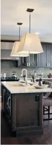  ?? BRUNO SCHLUMBERG­ER/OTTAWA CITIZEN ?? Oversized pendants from Restoratio­n Hardware over a kitchen island help create a rustic modern feel in Cardel’s Ovation model. ‘I just love the scale of them and I love the warmth that they created,’ says designer Kristina Hutchins.