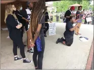  ?? EVAN BRANDT — MEDIANEWS GROUP ?? Nakialere Beasley knelt before the crowd Friday to show how a friend of his knelt before a police officer, help up her hands and said “don’t shoot officer, don’t shoot,” before being shot in the face by a rubber bullet by police.