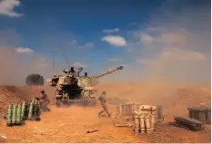  ?? | AFP ?? ISRAELI soldiers fire a 155mm self-propelled howitzer towards the Gaza Strip from their position near the southern Israeli city of Sderot.