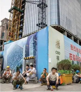  ?? FOTO REUTERS ?? Obreros migrantes, ayer a la hora del almuerzo en las obras de un proyecto en el distrito financiero de Pekín (China).