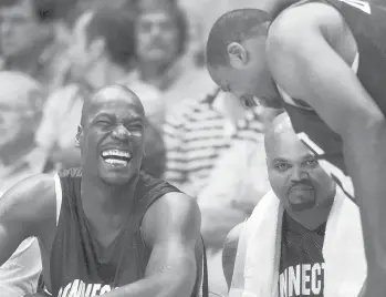  ?? STEPHEN DUNN/HARTFORD COURANT ?? It was old-home night for NBA star Clifford Robinson, left, as he shares a joke with former teammate Lyman DePriest, right, in 2002. In the center is former UConn star Chris Smith.