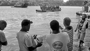  ?? BLOOMBERG ?? An October 2 picture of people waiting to be evacuate after the Manaro Voui volcano in Vanuatu continued to emenate smoke and ash