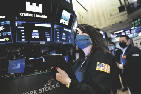  ?? NICOLE PEREIRA/NEW YORK STOCK EXCHANGE ?? IN THIS MARCH 10 PHOTO PROVIDED BY THE NEW YORK STOCK EXCHANGE, trader Phyllis Arena Woods works on the trading floor.