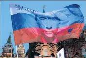  ?? Alexander Nemenov AFP/Getty Images ?? A RUSSIAN FLAG with an image of Vladimir Putin appears at a rally in Moscow in 2012 as his supporters celebrate his victory in the presidenti­al election.