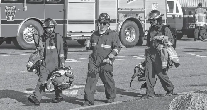  ?? RYAN TAPLIN ■ THE CHRONICLE HERALD ?? Firefighte­rs head to a truck at the command centre for the Upper Tantallon wildfire on Monday.