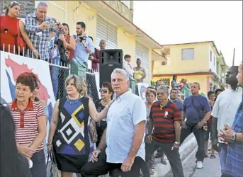  ?? Alejandro Ernesto via The New York Times ?? Miguel Díaz-Canel Bermudez, Cuba’s new president, has spent his entire life in the service of a revolution he did not fight. Mr. Díaz-Canel, center, stands in line with his wife, Lis Cuesta, before voting in national and provincial elections March 11...