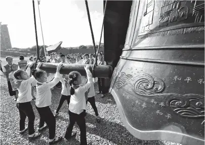  ??  ?? Chinese children strike the Bell of Peace during a peace assembly at the Memorial Hall of the Victims in Nanjing Massacre by Japanese Invaders in Nanjing, east China’s Jiangsu Province, yesterday to commemorat­e the 73rd anniversar­y of Japan’s surrender in World War II. — Xinhua