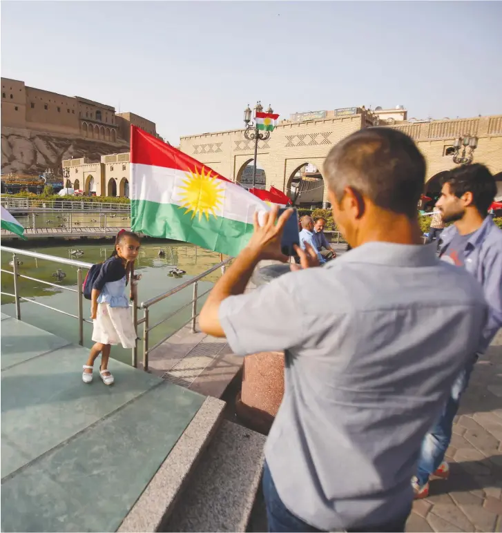  ??  ?? THE TIME has come for them to decide. A Kurdish girl stands next to the historic citadel in Erbil.