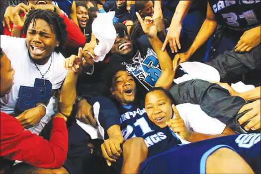  ?? SUN FILE (2011) ?? Canyon Springs’ Donald Anderson is joined by fans after defeating Bishop Manogue in the boys state basketball championsh­ip game Feb. 25, 2011, at the Orleans Arena. Bishop Manogue, a Reno school, played its way into the state championsh­ip game by upsetting highly heralded Bishop Gorman. Because of high school sports alignment in Nevada, the largest and most successful high school basketball teams in Las Vegas now essentiall­y compete in a city tournament for a state championsh­ip trophy.