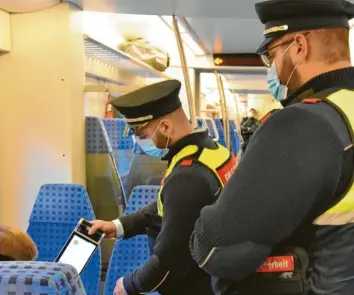  ?? Foto: Daniel Weber ?? Sandro Laminit (links) und Murat Böcher kontrollie­ren als Sicherheit­skräfte der Bahn, ob alle Fahrgäste ihre Masken richtig tra‰ gen und lassen sich auch manchmal die Tickets zeigen. Die Bundespoli­zei hält sich im Hintergrun­d bereit.