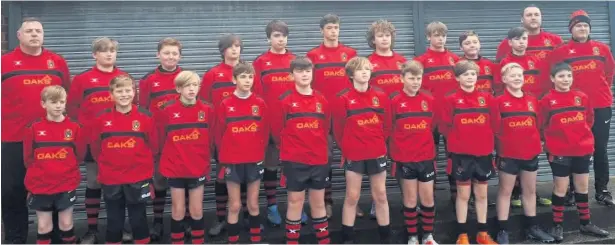  ??  ?? Widnes RUFC U13s players and their coaches are pictured wearing their new training tops sponsored by Wayne Hughes of Oaks Constructi­on. The dashing new kit certainly seemed to inspire the team, who later went on to thrash Bolton 55-5 at Heath Road.