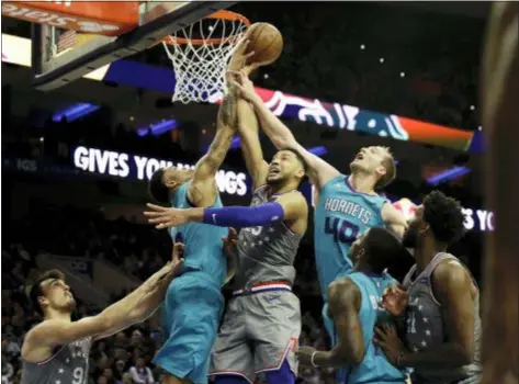  ?? MATT SLOCUM — THE ASSOCIATED PRESS ?? The Sixers’ Ben Simmons, center, tries to get a shot past Charlotte’s Miles Bridges, left, and Cody Zeller during the second half Friday.