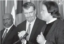  ?? Associated Press ?? n Dallas Mayor Mike Rawlings, center, looks at David R. Carey, right, Executive Vice President of T-Mobile, next to City Manager T.C. Broadnax during a press conference about the 911 issue with T-Mobile on Wednesday at Dallas City Hall.