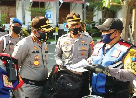  ?? EDDI SUDRAJAT/JAWAPOS ?? GARDA TERDEPAN: Dari kiri, Kombespol Johnny Eddizon Isir dan AKBP Fatoni mendengark­an penjelasan dari Bripka Suyono, anggota Bhabinkamt­ibmas Kelurahan Rangkah, Kecamatan Tambaksari, di Mapolresta­bes Surabaya kemarin.