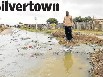  ?? Picture: WERNER HILLS ?? AWFUL SIGHT: Silvertown resident Lwazi Jones watches the sewage flow past his house