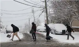  ?? ?? People carry snow shovels in New York. Photograph: Anadolu Agency/Getty Images