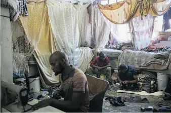  ?? PHOTOS: BRAM JANSSEN/THE ASSOCIATED PRESS ?? Migrant shoe makers work inside an abandoned building they occupy in Johannesbu­rg. Squatters say they want to see redevelopm­ent that would give them a proper home.