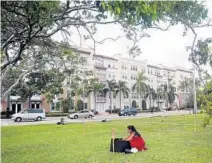  ??  ?? Renata Tapia plants a cacao seedling during a “sequential flash mob” in Fort Lauderdale on Friday.