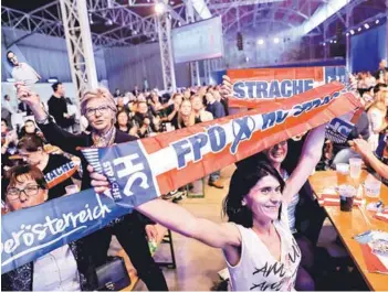  ??  ?? ► Partidario­s del FPÖ siguen el conteo de votos, ayer en Viena.