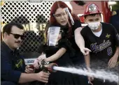  ?? ?? Ontario Fire Department members join Raylee’s birthday parade on Monday. They let Raylee, 5 and her brother Ryan, 10, use the fire hose for fun while their mother, Klarissa, watches.