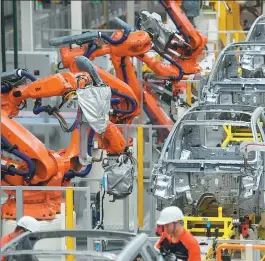  ?? HUANG ZHONGZHI / XINHUA ?? Assembly robots are used in the welding process at a Geely car production base in Ningbo, Zhejiang province.