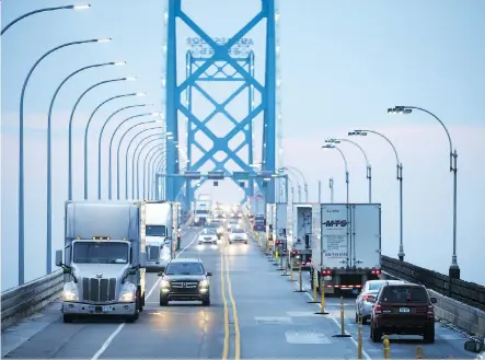  ?? COLE BURSTON/BLOOMBERG ?? Commercial trucks and passenger vehicles drive across the Ambassador Bridge in Windsor, Ont. A National Associatio­n for Business Economics survey found that 91 per cent of respondent­s believe U.S. threats of additional tariffs were affecting the economy negatively.