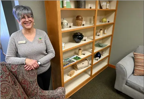  ?? JENNY SPARKS — LOVELAND REPORTER-HERALD ?? Becky Davis, general manager at The Natural Funeral, poses for a photo by some of their urns on Wednesday at the new funeral home in Loveland.