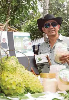  ??  ?? ROSYAM menunjukka­n produk
yang dihasilkan berasaskan durian
belanda.