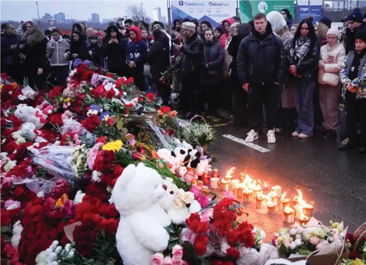  ?? ALEKSANDER ZEMLIANITS­JENKO / AP / NTB ?? Folk samlet seg lørdag for å legge ned blomster og tenne lys utenfor konsertlok­alet Crocus.