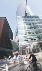  ??  ?? PEOPLE walk and cycle past Goldman Sachs headquarte­rs in New York City.