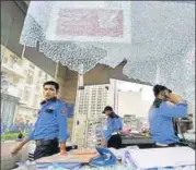  ?? SUNIL GHOSH/HT ?? Security guards inspect the damage at Mahagun Moderne society in Noida Sector 78 after it was attacked by locals.