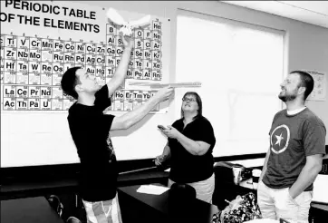  ??  ?? Steve Graner, a teacher at Oakland Catholic High School, Michelle McSwigan of Keystone Oaks High School and Charles Cerniglia of Wooster High School in Wooster, Ohio, perform an experiment in the AP physics workshop.