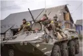  ?? EMILIO MORENATTI/AP ?? Ukrainian soldiers drive an armored military vehicle Saturday in the outskirts of Kyiv.